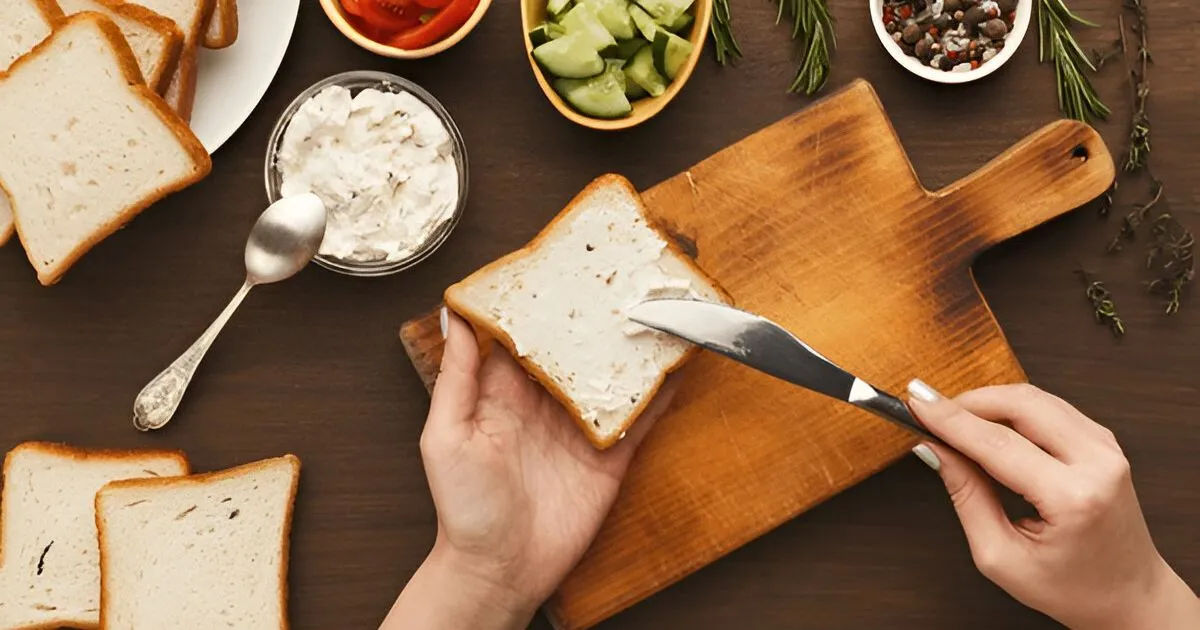 A creamy and smooth sweet cream cheese spread served in a bowl with fresh bagels, surrounded by ingredients like honey, vanilla, and berries.