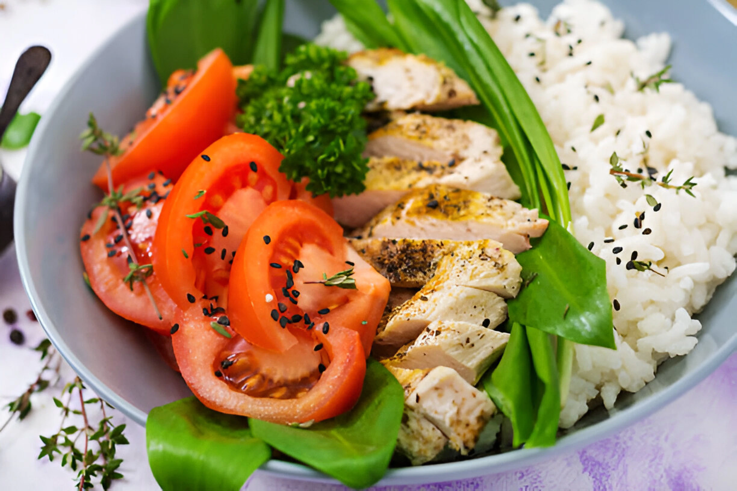 A delicious plate of fluffy rice served alongside a perfectly cooked salmon fillet, garnished with fresh herbs and a slice of lemon.