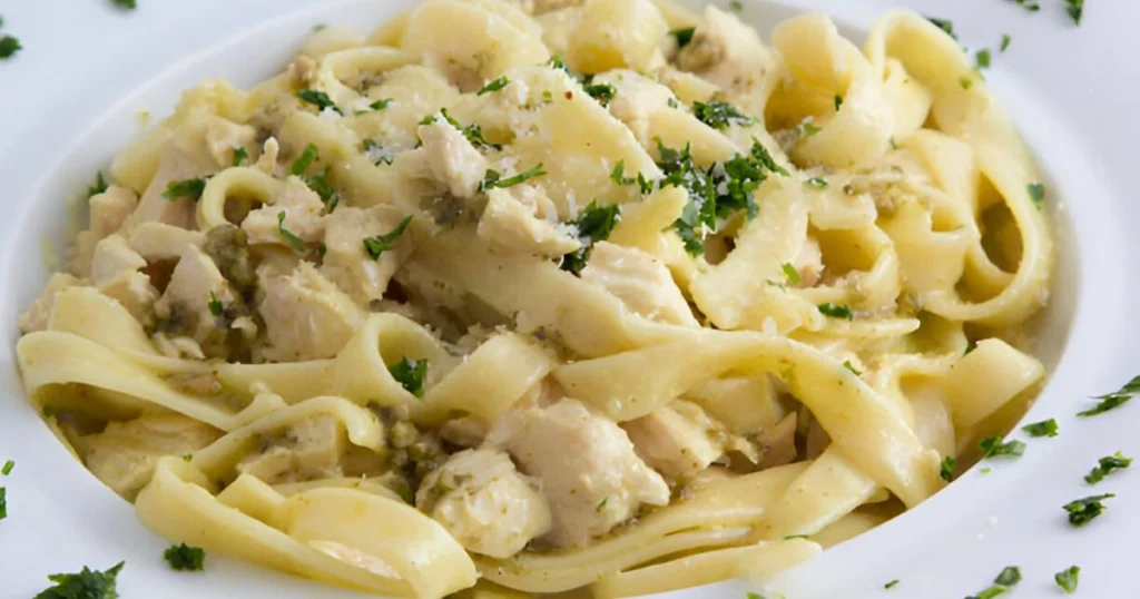 A creamy chicken Alfredo dish served with fettuccine pasta and garnished with fresh parsley, made using jarred Alfredo sauce.