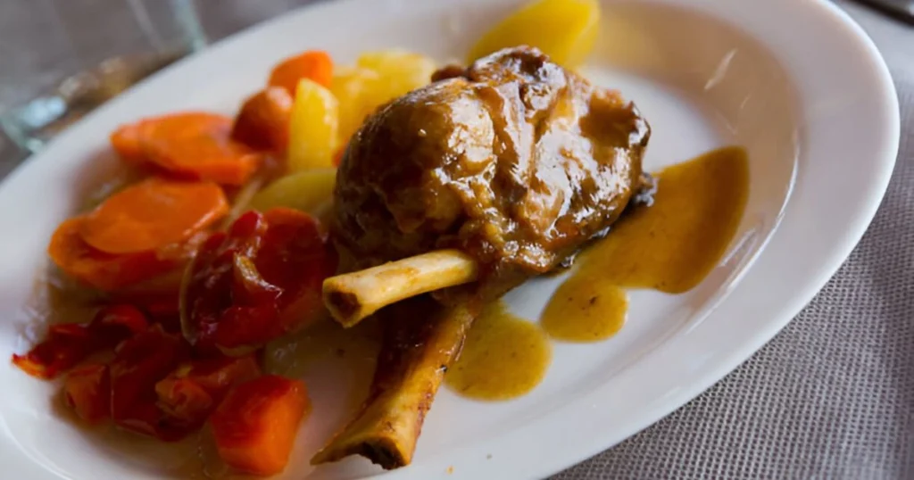 Delicious homemade hamburger steak served with rich brown gravy, garnished with fresh parsley, alongside mashed potatoes and steamed vegetables.